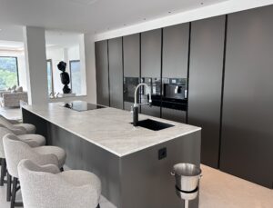 Une cuisine moderne et épurée mettant en valeur un îlot central, des matériaux haut de gamme et un design minimaliste.